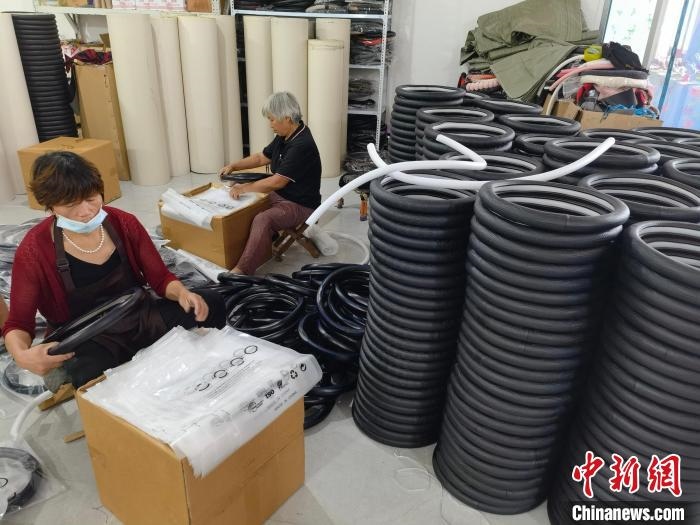 圖為村民在汽車飾品企業(yè)生產(chǎn)車間中工作?！巫雍?攝