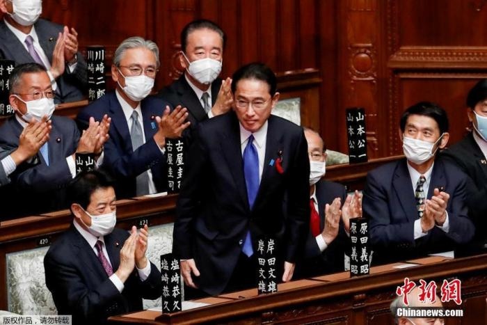 當?shù)貢r間10月4日，日本自民黨總裁岸田文雄經(jīng)過眾院全體會議的首相指名選舉成為第100任首相。圖為岸田文雄（中）起身致謝。