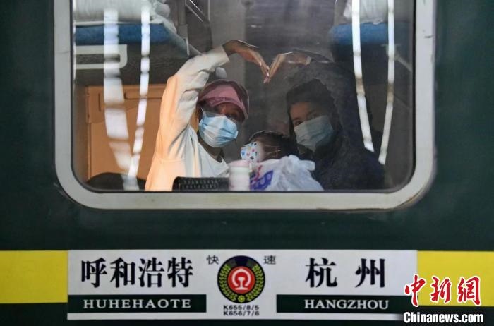 圖為登上轉(zhuǎn)運(yùn)火車(chē)的游客向額濟(jì)納比心?！⊥趵?攝