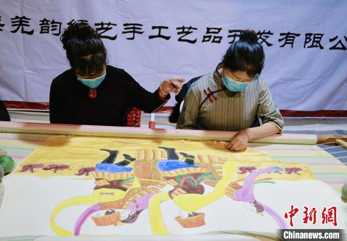 圖為皮繡藝人在市集上“秀”指尖技藝?！●R銘言 攝