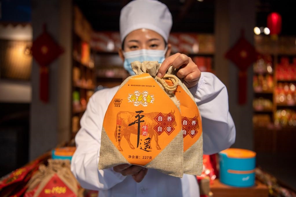 1月27日，在平遙古城南大街的一家平遙牛肉店內(nèi)，工作人員展示一款牛肉產(chǎn)品。新華社記者 楊晨光 攝