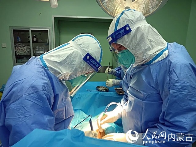 醫(yī)護(hù)人員正在為新冠肺炎合并腸梗阻腸穿孔的尿毒癥患者實(shí)施急診手術(shù)。呼和浩特市第一醫(yī)院供圖