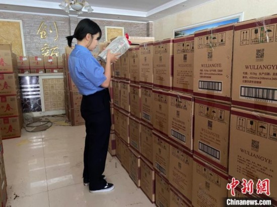 資料圖為檢察人員核對查獲的假冒品牌白酒。青海省人民檢察院供圖