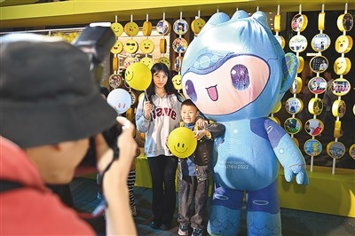 5月7日，在浙江省杭州市湖濱步行街“3D笑臉墻”前，攝影師為游客與杭州亞運(yùn)會(huì)吉祥物之一“宸宸”拍攝合影。