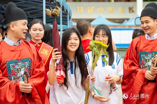 6月7日上午，在南寧市天桃實(shí)驗(yàn)學(xué)校翠竹校區(qū)，老師們?cè)跒榭忌鷤兗佑凸膭?！人民網(wǎng)記者 嚴(yán)立政攝
