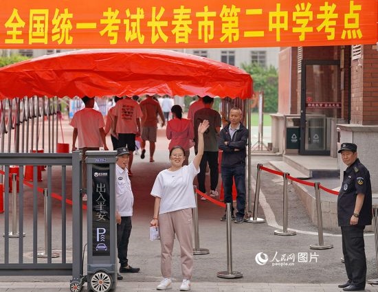 6月7日，在長春市第二中學(xué)考點(diǎn)，一名考生信心滿滿進(jìn)入考場，并與家長揮手致意。人民網(wǎng)記者 李洋攝
