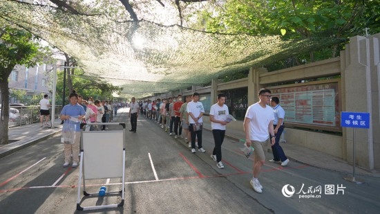 6月7日，烏魯木齊市第七十中學(xué)門口，考生們有序進(jìn)入考場。人民網(wǎng) 李欣洋攝