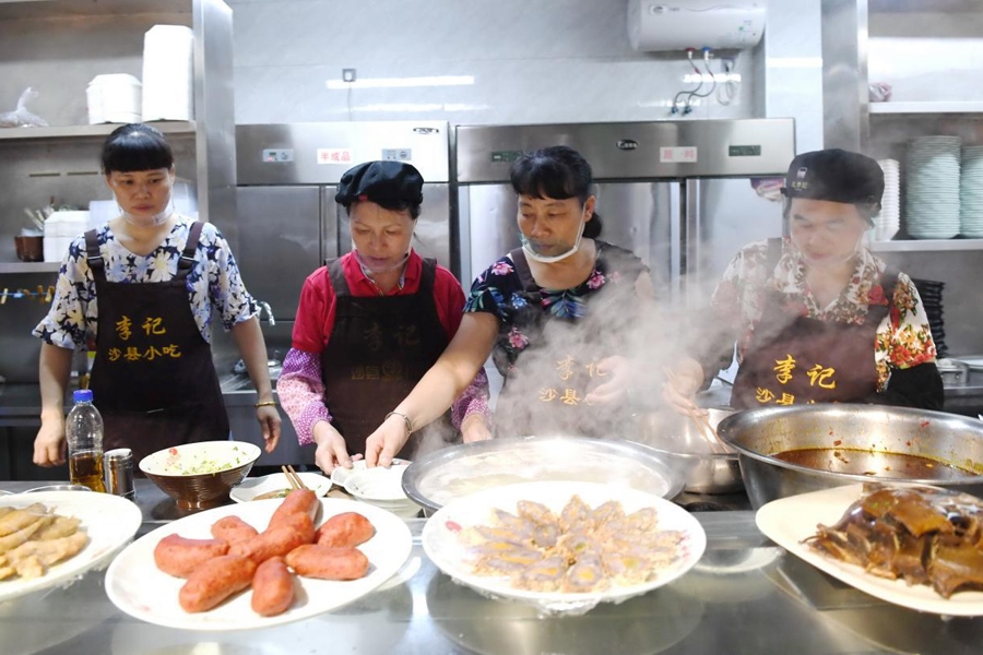 福建三明市沙縣區(qū)一家小吃店工作人員在為客人準(zhǔn)備特色小吃。 新華社記者 林善傳 攝