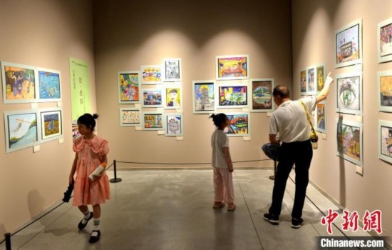 圖為家長(zhǎng)帶著孩子參觀展覽。呂明 攝