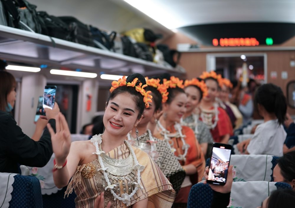 2023年4月13日，老撾工作人員在D887次國際旅客列車上表演。當(dāng)日，中老鐵路從中國昆明南站、老撾萬象站雙向?qū)﹂_D887次和D888次國際旅客列車，兩地乘火車可當(dāng)日通達(dá)。中老鐵路是高質(zhì)量共建“一帶一路”的標(biāo)志性工程。新華社記者 邢廣利 攝