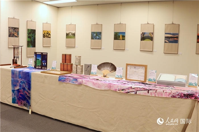 現(xiàn)場(chǎng)展出的馮學(xué)敏攝影作品與湖州市特色工藝品。（人民網(wǎng) 許可攝）