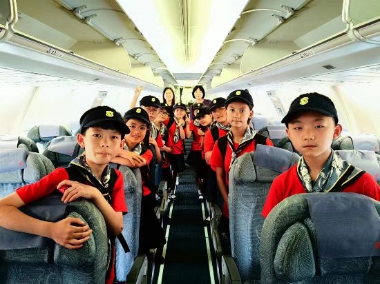 文縣東壩童聲合唱團(tuán)的孩子們?cè)陲w機(jī)上。