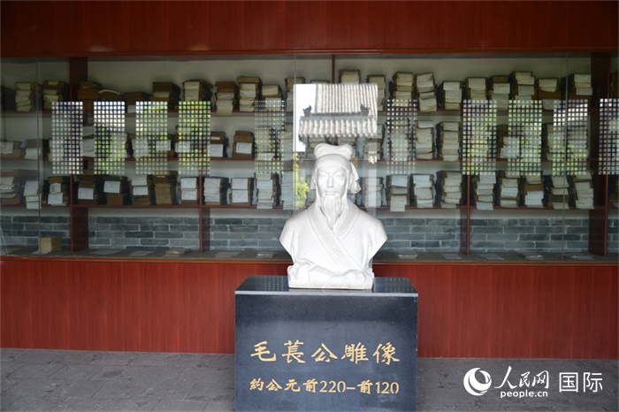河間詩(shī)經(jīng)齋毛萇雕像。雕像后書(shū)櫥中陳列的是歷代各版本《詩(shī)經(jīng)》及譯本。 人民網(wǎng) 趙昭攝