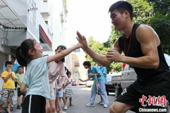 圖為大學(xué)生志愿者在組織孩子們參加體育健身活動(dòng)。廖光福 攝