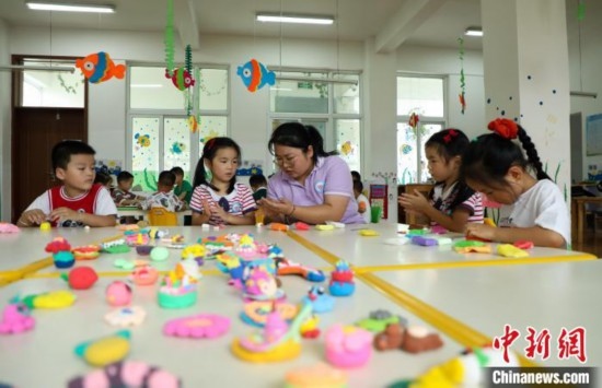 在肥西縣山南鎮(zhèn)中心幼兒園，孩子們?cè)诶蠋煹闹笇?dǎo)下做彩色泥塑。陳家樂(lè) 攝