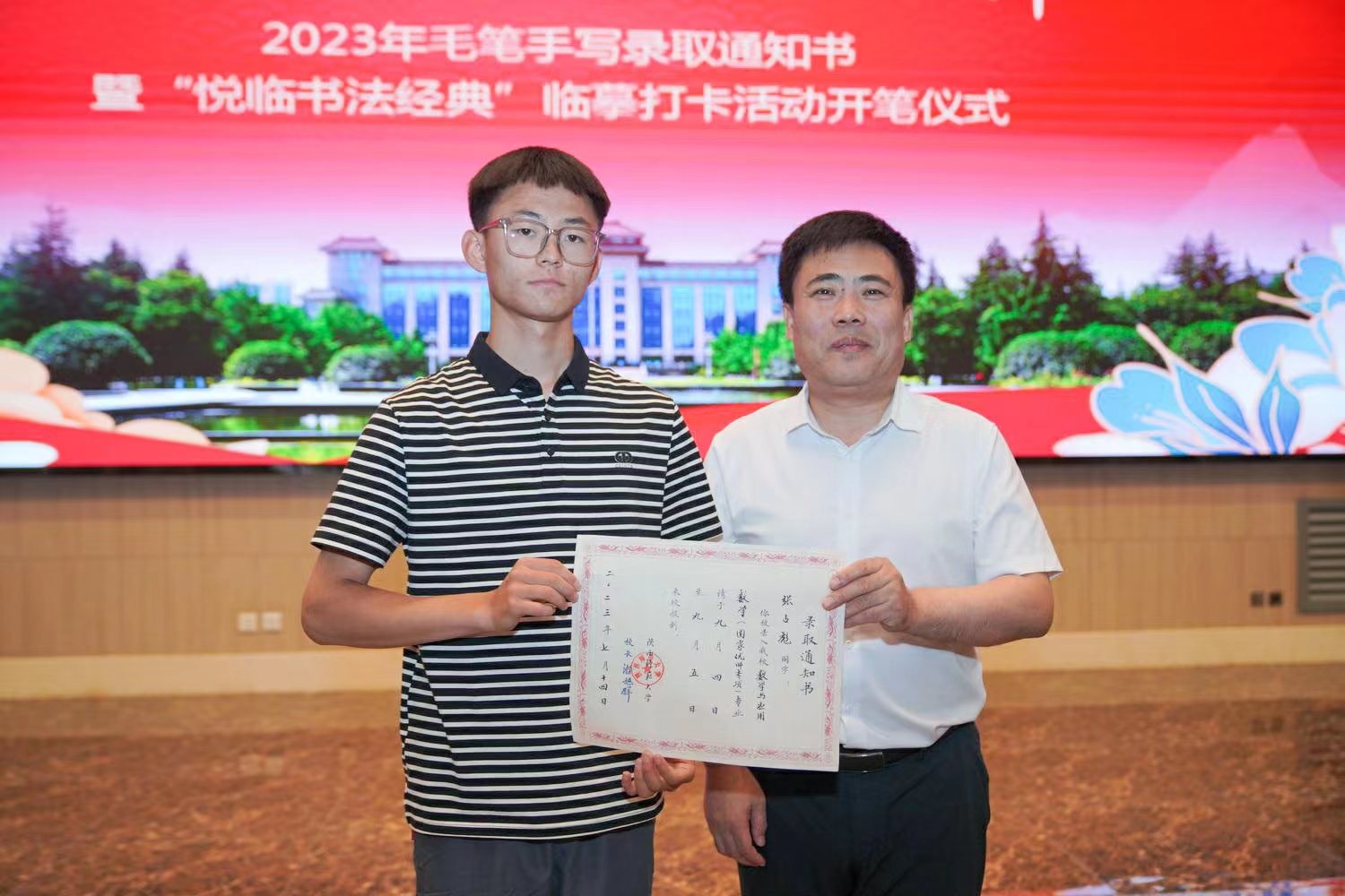 陜西師范大學(xué)黨委書(shū)記李忠軍為2023級(jí)新生代表張占彪同學(xué)發(fā)放錄取通知書(shū)。校方供圖