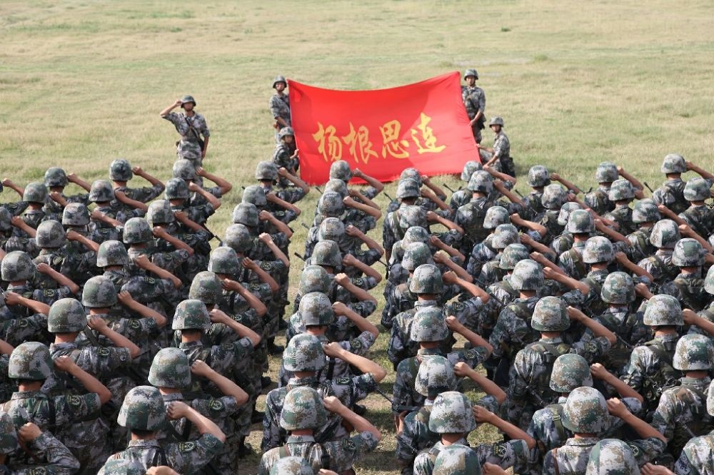↑“楊根思連”官兵執(zhí)行任務(wù)前向連旗宣誓（資料照片）。新華社發(fā)