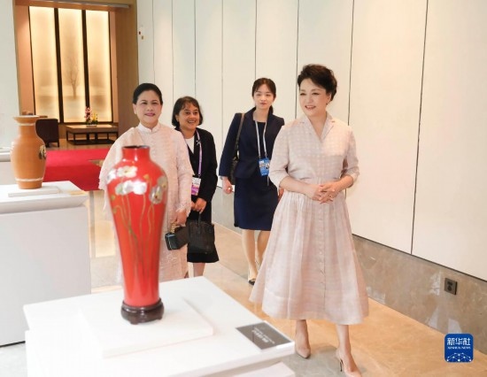 7月27日下午，國(guó)家主席習(xí)近平夫人彭麗媛在四川成都會(huì)見陪同印度尼西亞總統(tǒng)佐科來華出席第31屆世界大學(xué)生夏季運(yùn)動(dòng)會(huì)開幕式并訪華的總統(tǒng)夫人伊莉亞娜。這是彭麗媛和伊莉亞娜欣賞成都特色非遺工藝品。新華社記者 丁林 攝