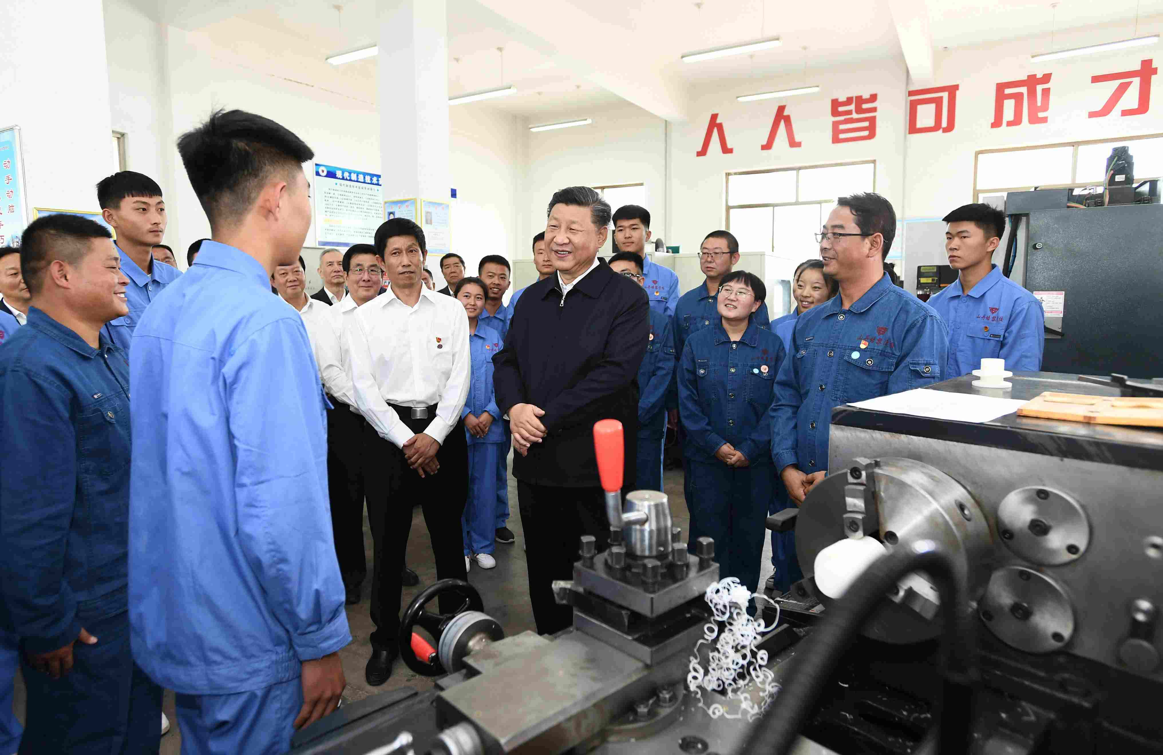 2019年8月20日，習(xí)近平在甘肅省張掖市山丹培黎學(xué)?，F(xiàn)代制造技術(shù)實(shí)訓(xùn)室，觀看職業(yè)技能實(shí)訓(xùn)，同師生親切交流。