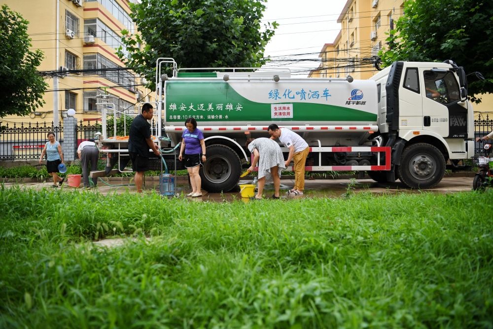 河北省涿州市新星小區(qū)居民從供水車?yán)锝铀?月4日攝）。新華社記者 牟宇 攝