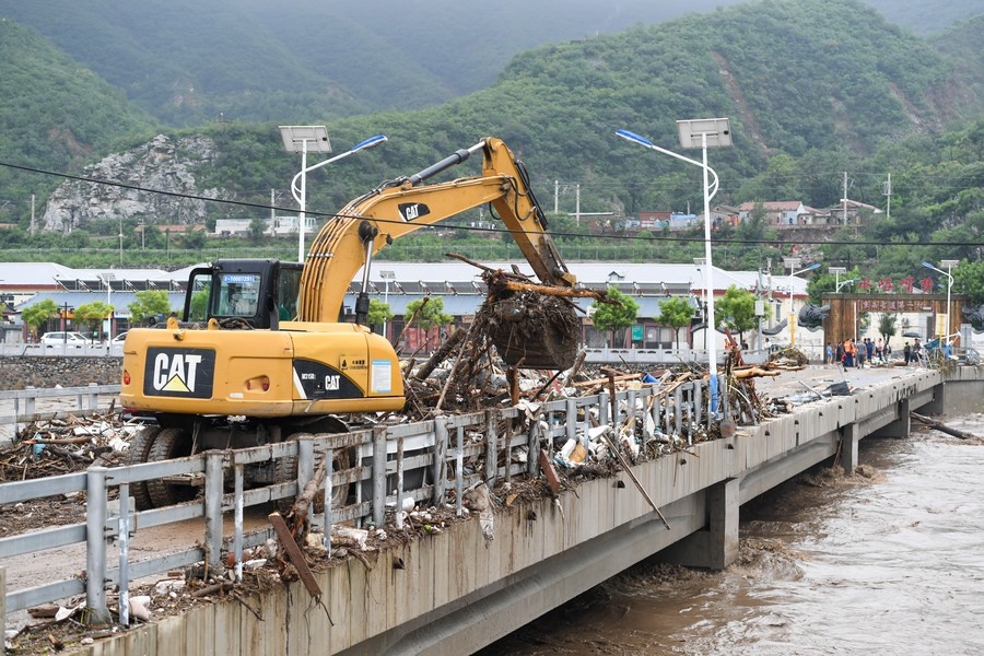 8月1日，在北京市門頭溝區(qū)水峪嘴村村口，一臺(tái)挖掘機(jī)在清理阻斷橋梁交通的雜物。目前該條道路已經(jīng)疏通完成。新華社記者 鞠煥宗 攝