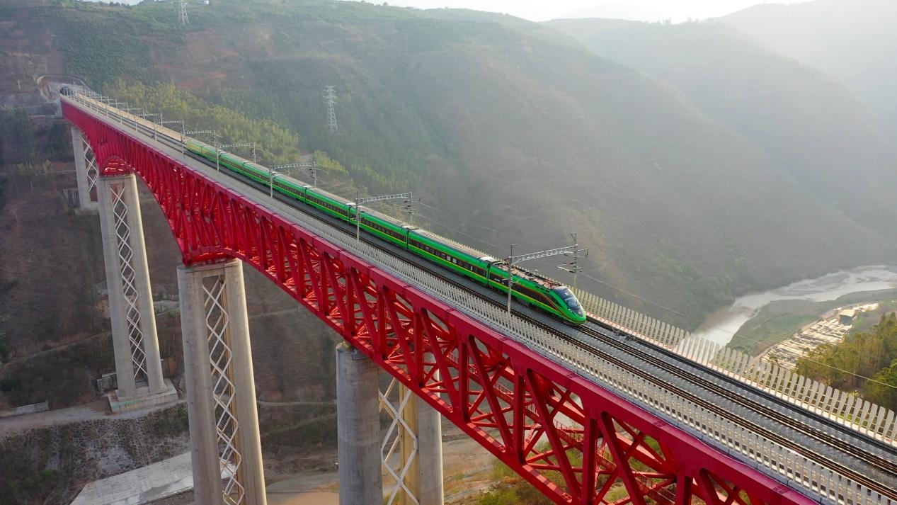 中老鐵路國際旅客列車在云南省境內(nèi)的元江特大橋上飛馳。姚巍攝