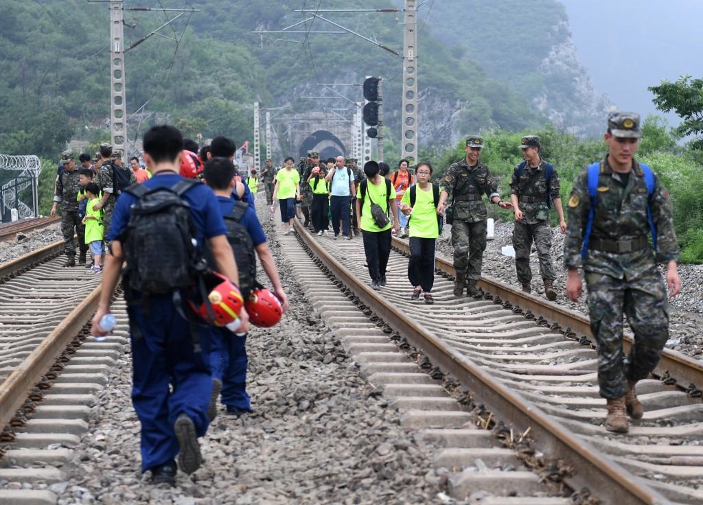 8月2日，部分滯留在北京市門頭溝山區(qū)受困列車的旅客，在救援人員幫助下前往轉運客車。新華社記者張晨霖 攝