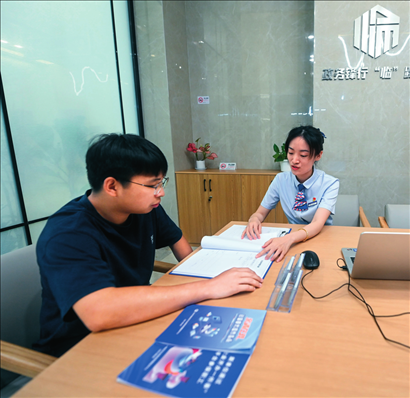 在杭州市臨安區(qū)政務(wù)服務(wù)中心的“為企服務(wù)中心”，黨員志愿者（右）解答企業(yè)主的疑問（2023年7月7日攝）。徐昱攝/本刊