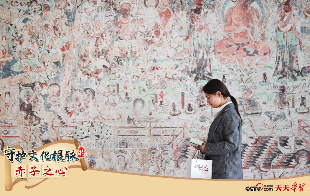2023年4月25日，敦煌研究院文物數(shù)字化保護(hù)團(tuán)隊(duì)創(chuàng)意營(yíng)銷人員廖雪婷從一幅高保真復(fù)制壁畫前走過(guò)。
