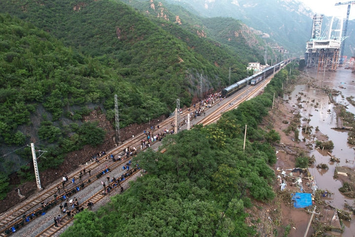 8月2日，受困列車旅客在救援人員幫助下徒步趕往轉(zhuǎn)運(yùn)客車（無人機(jī)照片）。新華社記者 張晨霖 攝
