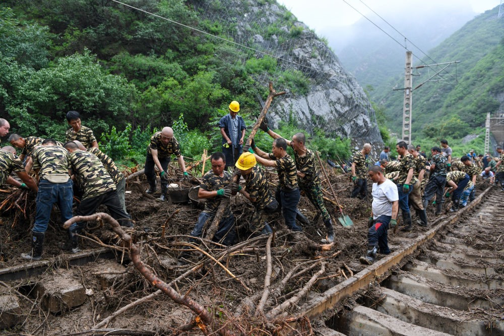 8月1日，在北京市門頭溝區(qū)水峪嘴村附近一段被阻斷的鐵路線上，中鐵六局工作人員在清理軌道上的雜物，全力恢復(fù)交通。新華社記者 鞠煥宗 攝