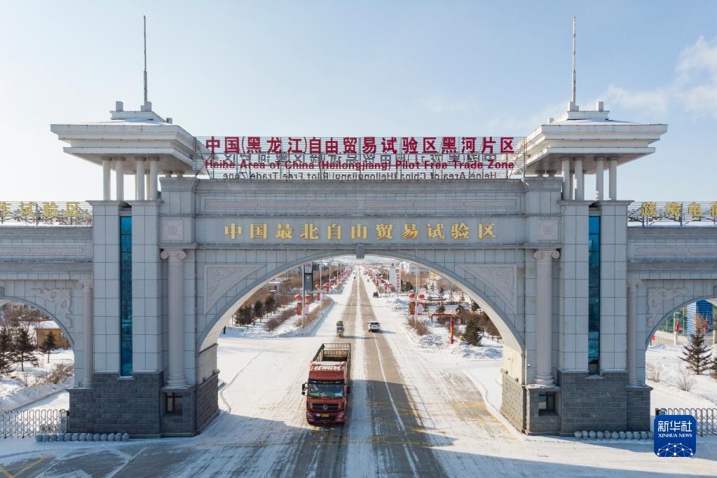 2月11日，車輛駛出中國(guó)（黑龍江）自由貿(mào)易試驗(yàn)區(qū)黑河片區(qū)大門（無(wú)人機(jī)照片）。新華社記者 謝劍飛 攝