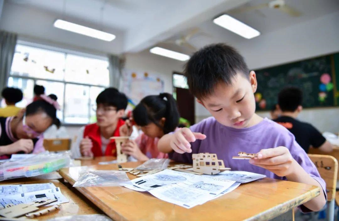 △今年7月，在浙江余姚市舜北小學(xué)暑托班內(nèi)，孩子們制作太陽能科學(xué)實(shí)驗(yàn)裝置。