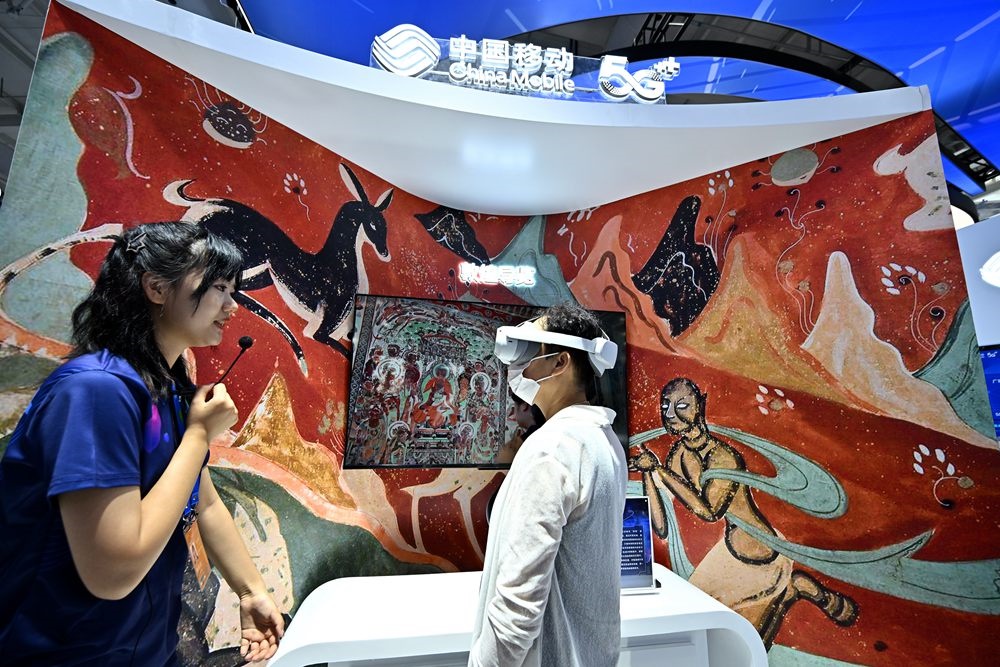 9月3日，一名參觀者在首鋼園中國移動展臺體驗基于AR/VR特效的敦煌導(dǎo)覽，沉浸式感受敦煌壁畫的魅力。新華社記者 李鑫 攝
