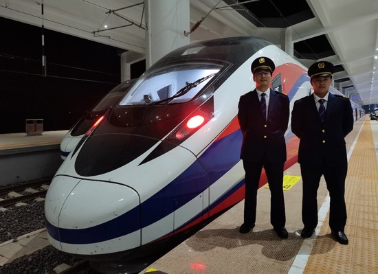 劉銀能（右一）與中國師父鄔俊鴻在動車組前合影。受訪者供圖