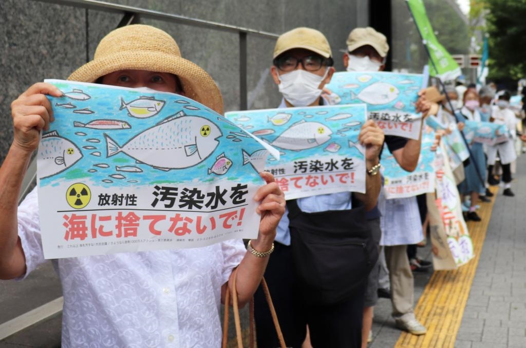 8月24日，日本民眾手持“不要將污染水扔進大?！钡葮?biāo)語在東京電力公司總部前集會，抗議日本政府和東電公司無視民意啟動核污染水排海。新華社記者楊光攝