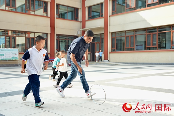 來自巴基斯坦的沙杰在滾鐵環(huán)。人民網(wǎng) 盧鵬宇攝