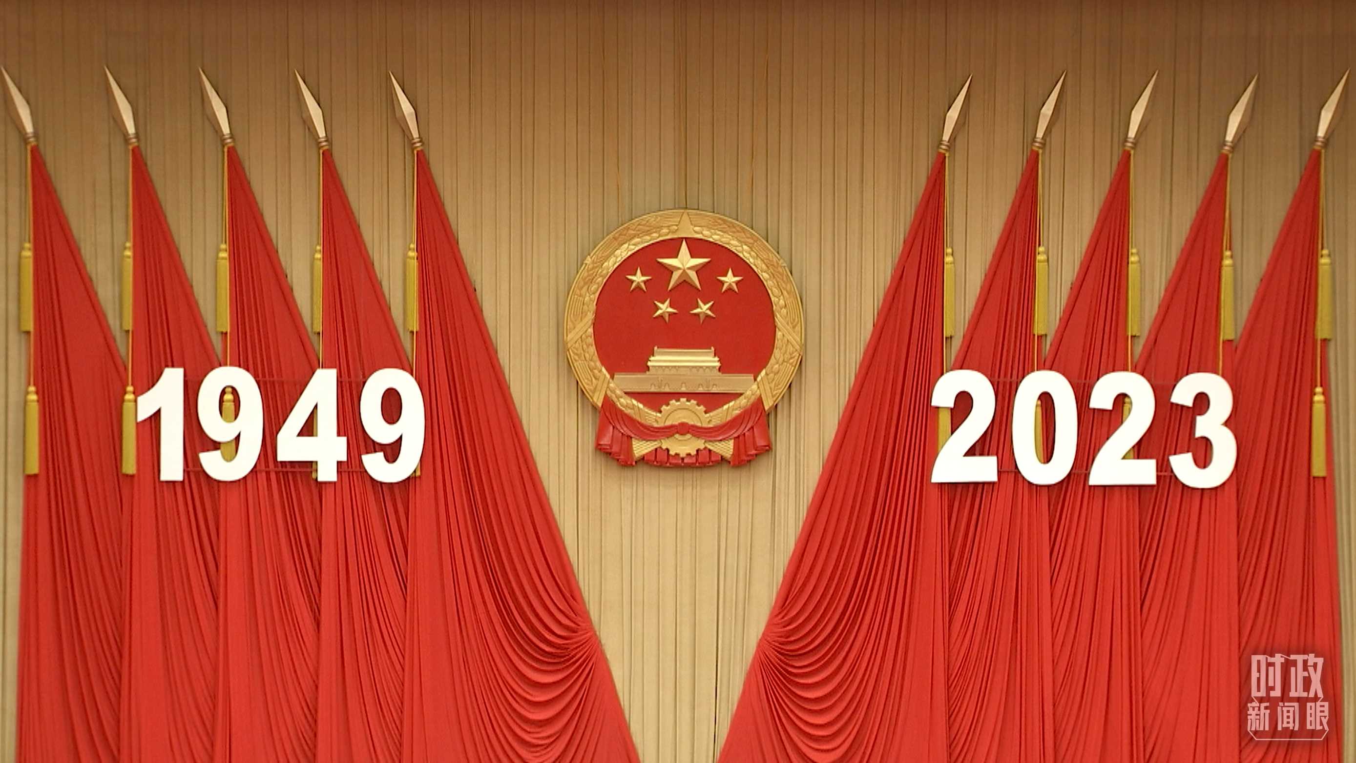 △人民大會堂宴會廳內(nèi)，主席臺上方高懸著莊嚴(yán)的國徽，“1949－2023”大字年號在鮮艷的紅旗映襯下格外醒目。