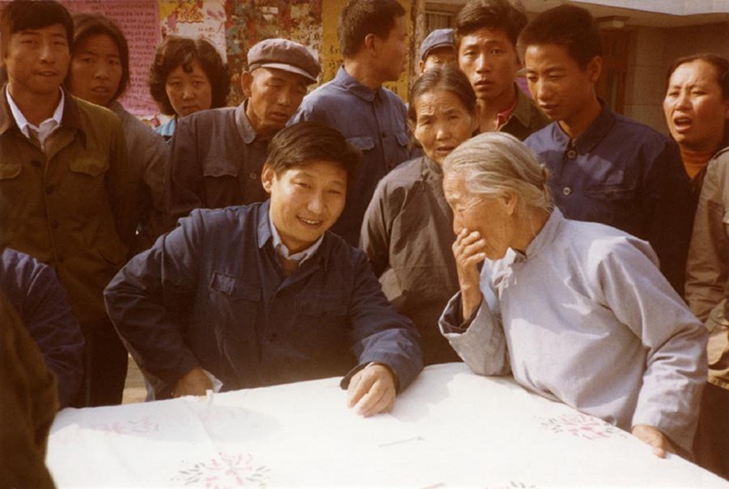 1983年，時(shí)任河北正定縣委書記的習(xí)近平（前排居中）臨時(shí)在大街上擺桌子聽(tīng)取老百姓意見(jiàn)。