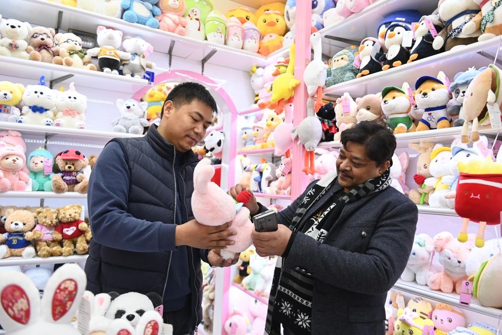2023年2月2日，來(lái)自印度的客商（右）在義烏國(guó)際商貿(mào)城的一家玩具店鋪內(nèi)選購(gòu)商品。新華社記者 黃宗治 攝