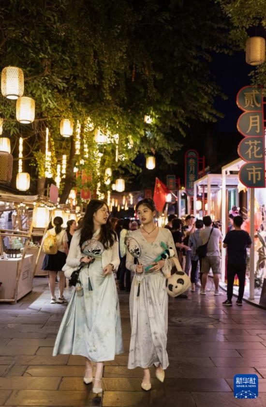 在成都寬窄巷子，兩位來(lái)自安徽的游客在新“十二月市”街區(qū)游覽（9月29日攝）。