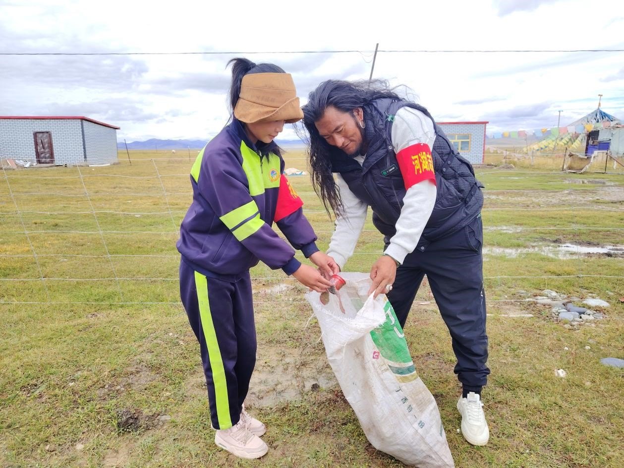 玉樹(shù)州稱多縣珍秦鎮(zhèn)河湖志愿者才培和他女兒更求拉毛在清掃垃圾。受訪者供圖