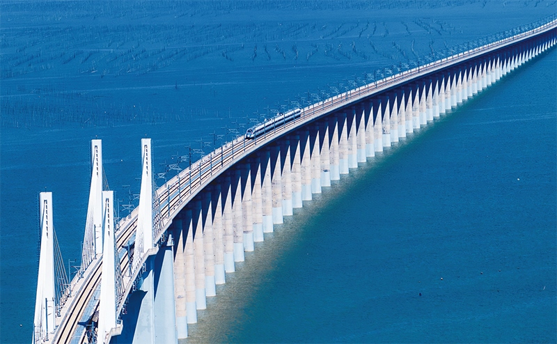 2023年9月28日，中國首條時速350公里跨海高鐵——福廈高鐵正式開通運營。圖為一列運行試驗車組駛過福廈高鐵湄洲灣跨海大橋（9月19日攝，無人機照片）。 新華社記者 魏培全/攝