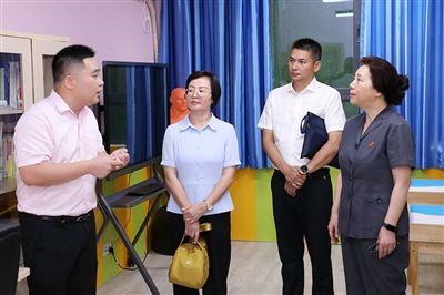 圖③：“小公民法律課堂”開講前，全國人大代表殷其龍（右二）、重慶市人大代表李自玲（左二）聽取楊家坪中學負責人關(guān)于未成年人思想教育工作情況的介紹。