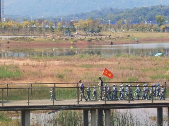 10月24日，秋游的幼兒園小朋友在老師帶領(lǐng)下走在清水塘公園里的木橋上。本報(bào)記者 常雯宜攝