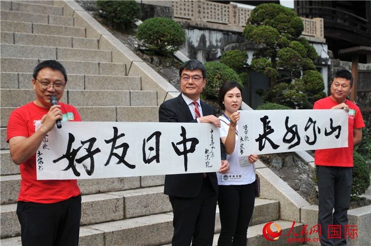 東京中國文化中心主任羅玉泉展示其為本次活動書寫的題詞“中日友好，山高水長”。人民網(wǎng) 蔣曉辰攝