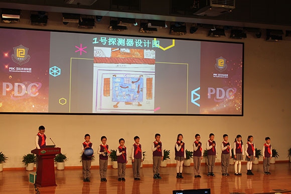 北京呼家樓中心小學(xué)的學(xué)生們展示PDC項(xiàng)目“新行星移民計(jì)劃探索衛(wèi)星設(shè)計(jì)”。