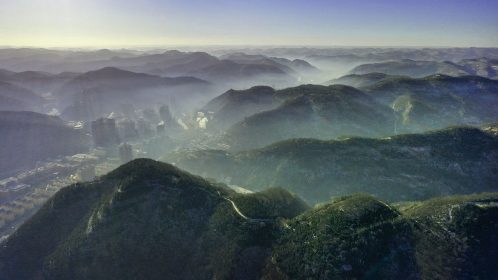 陜西省延安市吳起縣的山山峁峁被茂密的山林覆蓋（2021年12月20日攝，無(wú)人機(jī)照片）。新華社記者 陶明 攝
