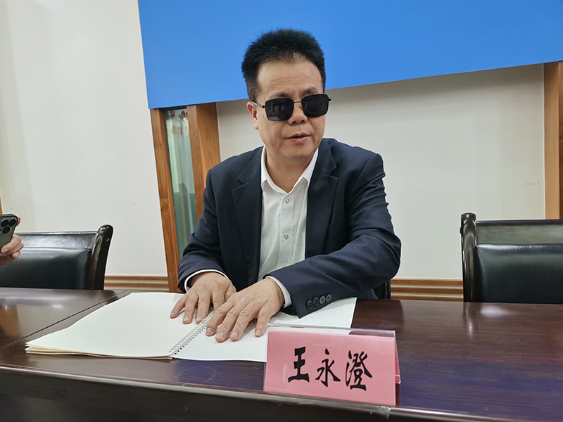 全國人大代表王永澄正在閱讀盲文版代表建議答復(fù)。本報(bào)記者 張 璁?dāng)z