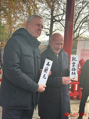 柏林市長(zhǎng)韋格納（右）、動(dòng)物園監(jiān)事會(huì)主席布魯克曼（左）手持中國(guó)文化中心工作人員現(xiàn)場(chǎng)手書(shū)的中文名字。人民網(wǎng)記者 徐馨攝